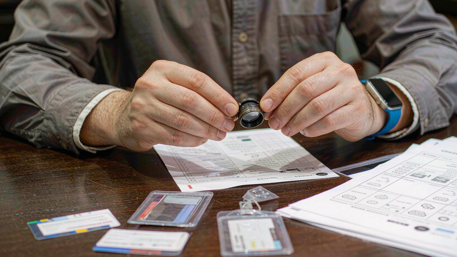 Engineer inspecting personalized cards with a loupe during QC